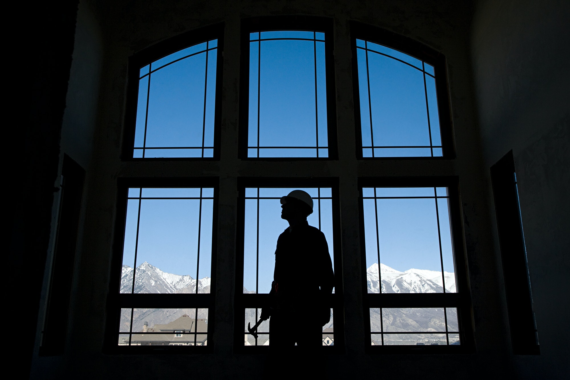 Silhouette of a builder against a window