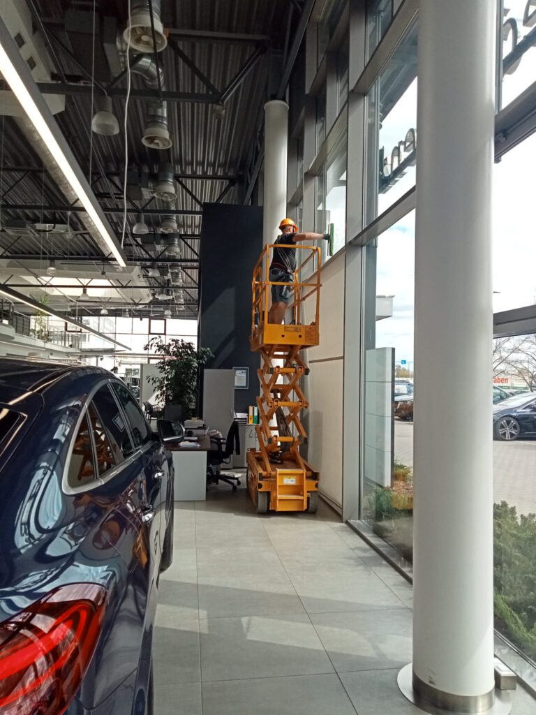 Mycie przeszkleń z podnośnika nożycowego wewnątrz salonu Mercedes-Benz Auto Idea Olsztyn